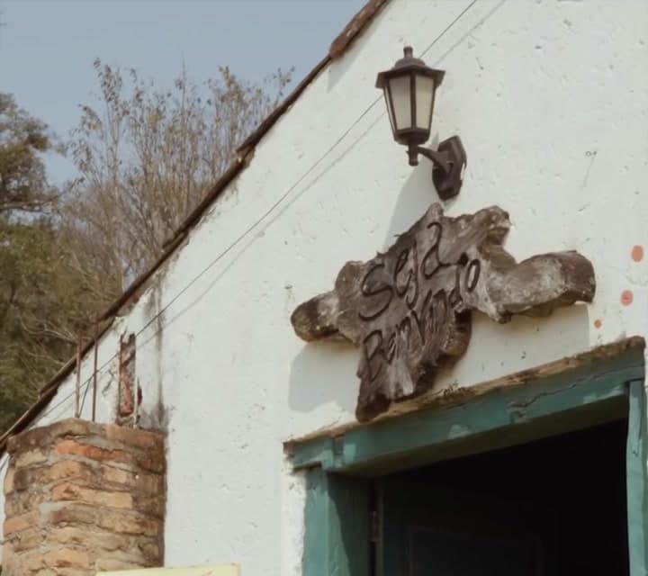 Porta verde do casarão com ornamento na fachada e lampião